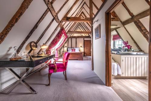 een zolderkamer met een bureau en een slaapkamer bij The Great House Lavenham Hotel & Restaurant in Lavenham