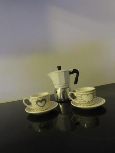 two cups and two saucers on a table with a coffee maker at Cuore nel Borgo in Borgo