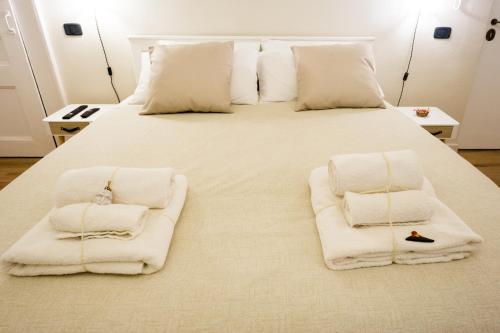 a large white bed with white towels on it at Residenza Sforza Apartment 1 in Naples