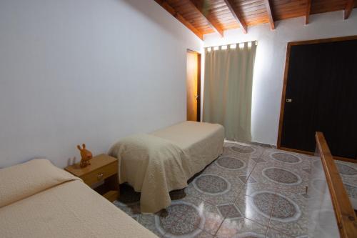 a bedroom with two beds and a television in it at Departamento Casimiro-Nuevo Amplio en Zona Centro in El Calafate