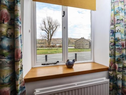 a window with a vase on a wooden window sill at Anglers Barn in Skipton