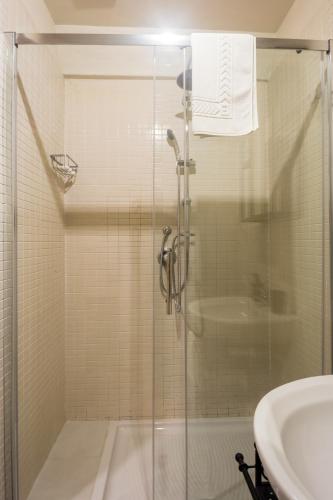 a shower with a glass door next to a sink at Residenza Sforza Apartment 1 in Naples