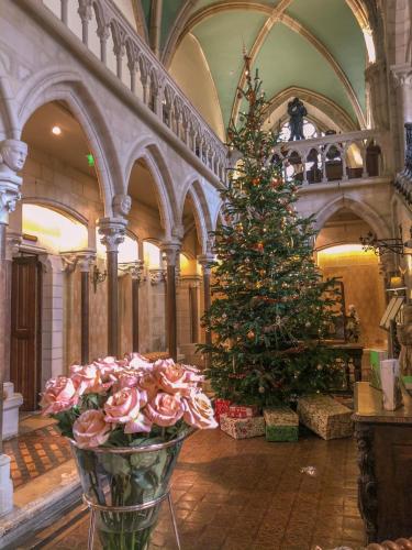 a christmas tree in a room with a vase of flowers at Abbaye de la Bussière in La Bussière-sur-Ouche
