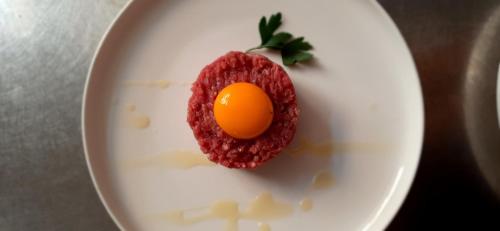 a white plate with an egg in a red dessert at Hotel Ristorante San Celso in Varazze