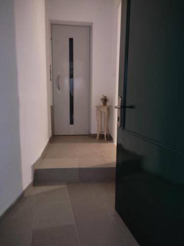 an empty hallway with a door and a table at DORA'S APARTMENTS STUDIO 1 in Corfu
