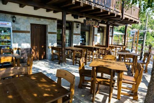un restaurante vacío con mesas y sillas de madera en Delchovski Han en Delchevo
