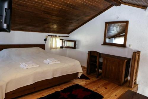 1 dormitorio con cama y espejo en la pared en Delchovski Han en Delchevo