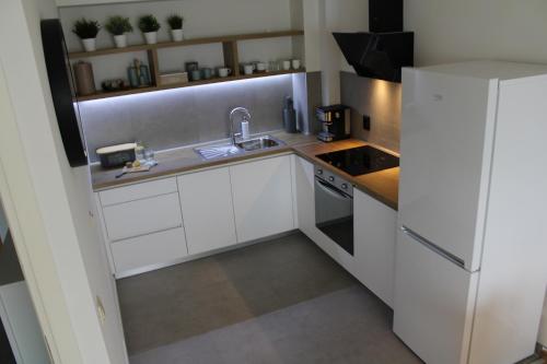 eine kleine Küche mit weißen Schränken und einem Waschbecken in der Unterkunft Arena Zagreb Premium Apartment in Zagreb