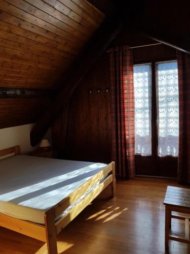 Chalet Le Sambuis في Saint-Colomban-des-Villards: سرير في غرفة بها نافذتين