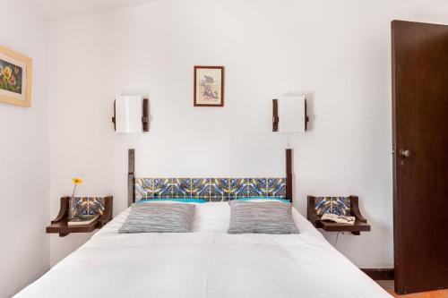 a bedroom with a large white bed with two chairs at Gerês Mountain Lake Views in Geres