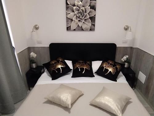 Una cama con almohadas blancas y negras. en Apartment Marifra Garden, en Taormina