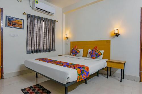 een slaapkamer met een groot bed en een bureau bij FabExpress Crystal Stay in Bhubaneshwar