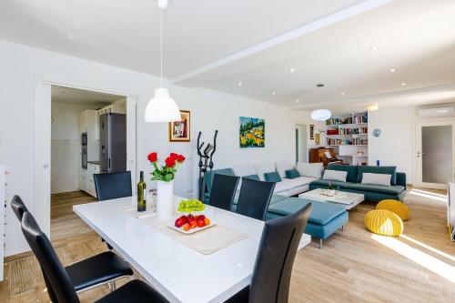a dining room and living room with a white table and chairs at Villa Rubea in Cavtat