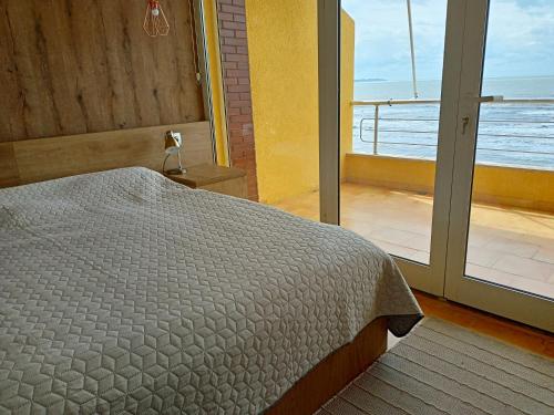a bedroom with a bed and a view of the ocean at Apartmán Dagmar in Durrës