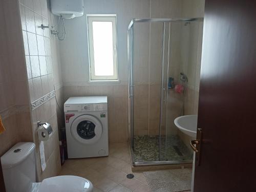 a bathroom with a washing machine and a sink at Apartmán Dagmar in Durrës
