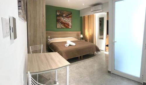a bedroom with a bed and a green wall at Dghajsa GUEST HOUSE in Senglea