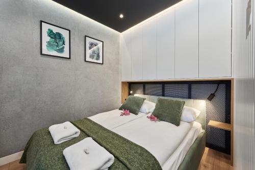 una camera da letto con un grande letto bianco con cuscini verdi di Lux Apartment Browary Wrocławskie by Renters a Breslavia