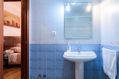 馬托斯的住宿－Céntrico Alojamiento，蓝色瓷砖浴室设有水槽和镜子
