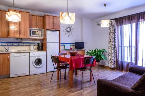 馬托斯的住宿－Céntrico Alojamiento，厨房以及带红色桌椅的起居室。