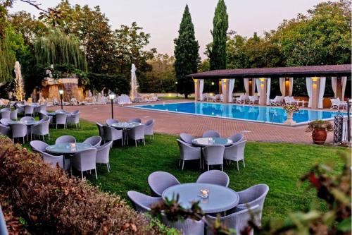 a group of tables and chairs next to a pool at Aminta Resort in Genazzano