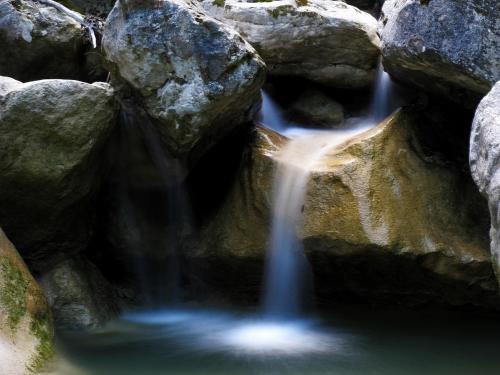 a waterfall in a pool of water next to rocks at Hotel Miami in Civitella del Tronto