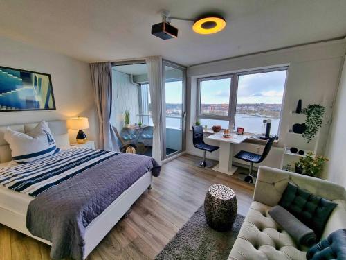 a bedroom with a bed and a desk with a table at Traumblick! Mitten im Wasser, dem Himmel ganz nah! in Schleswig