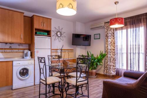 eine Küche und ein Esszimmer mit einem Tisch und Stühlen in der Unterkunft Coqueto Alojamiento in Martos