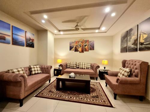 a living room with two couches and a coffee table at Luxurious Landing Apartments & Suites Bahria Town in Rawalpindi