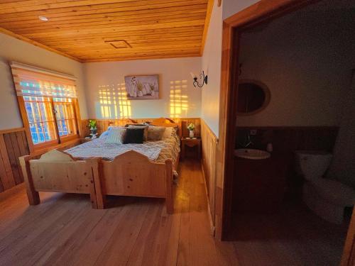 a bedroom with a large bed and a bathroom at Auberge au Poste de Traite in Sainte-Famille