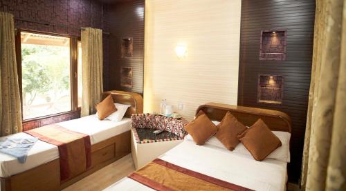 a room with two beds and a window at Chitwan Forest Resort , Chitwan National Park in Sauraha