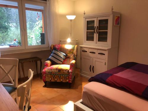 een slaapkamer met een bed, een stoel en een kast bij Haus 3 Birken in Ramberg