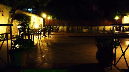 a patio with tables and chairs at night at Hotel Bakos in Loutraki