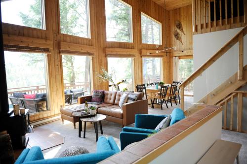 un soggiorno con mobili e finestre di Mid Century Modern Mountain Cabin a Invermere