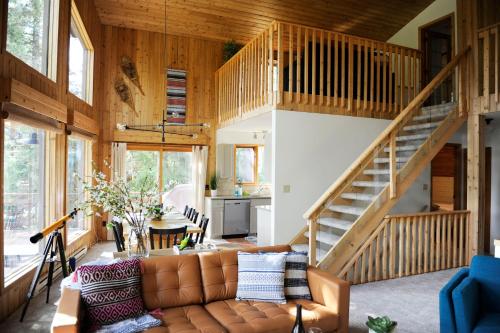 ein Wohnzimmer mit einem Sofa und einer Treppe in der Unterkunft Mid Century Modern Mountain Cabin in Invermere