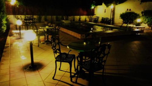 a patio with a table and chairs next to a pool at Hotel Bakos in Loutraki