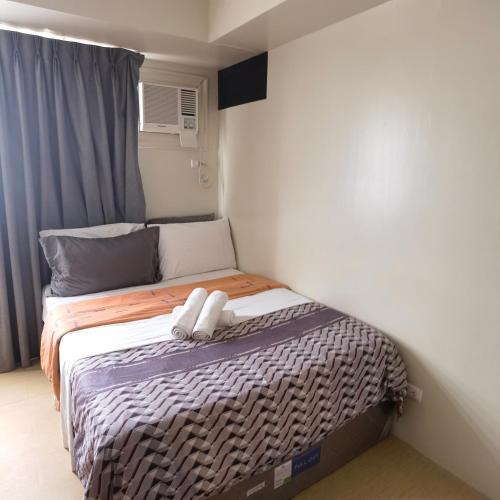 a small bed with two white towels on it at Avida Davao Condos, downtown CM Recto Avenue, Davao City in Davao City