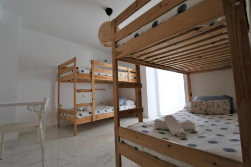 a bedroom with two bunk beds and a desk at Casa Rural Mañanas Felices in Martos