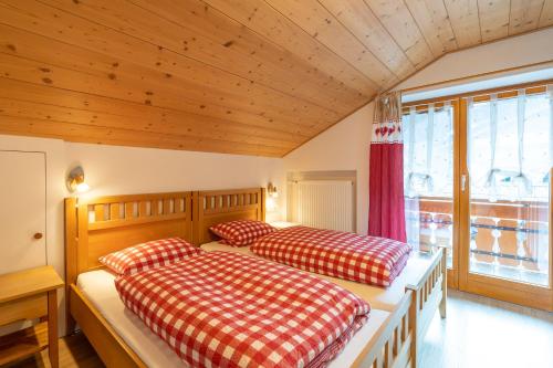 2 camas en una habitación con techos de madera en Alpenliebe Ferienwohnung, en Ofterschwang