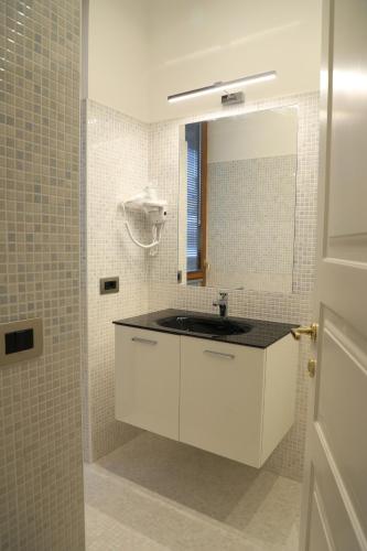 a white bathroom with a sink and a mirror at Gemelli Hotel in Rome