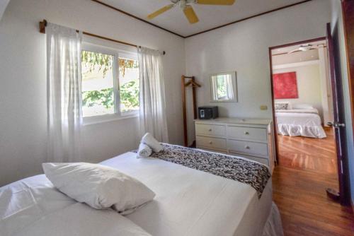 a bedroom with a white bed and a window at Montelaguna Boutique Hotel in Sámara