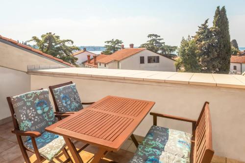 een balkon met een houten tafel en 2 stoelen bij Apartments Villa Pavle in Rovinj