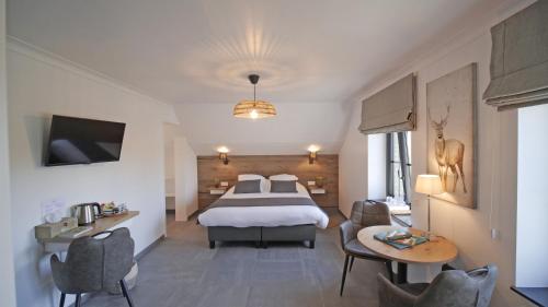 a hotel room with a bed and a table and chairs at Auberge la Hutte Lurette in Paliseul
