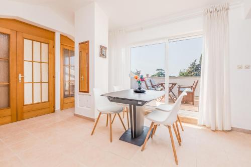 een eetkamer met een tafel en stoelen en een raam bij Apartments Villa Pavle in Rovinj