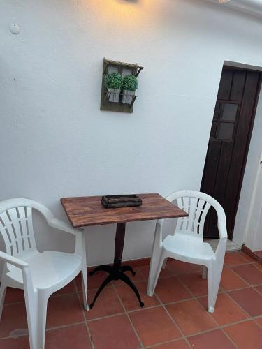 a table and two white chairs sitting next to a table and a table at A Casinha da Vila in Vila Viçosa