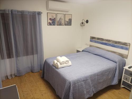 a bedroom with a bed with two towels on it at Casa La Piedra in Segura de la Sierra