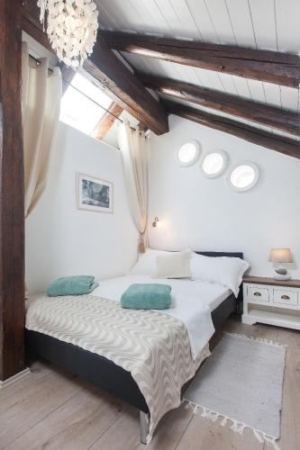 a bedroom with two beds and a chandelier at Villa Oliva in Podgora