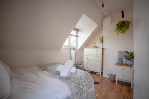 1 dormitorio con 1 cama, vestidor y ventana en St Owen's Terrace by RentMyHouse en Hereford