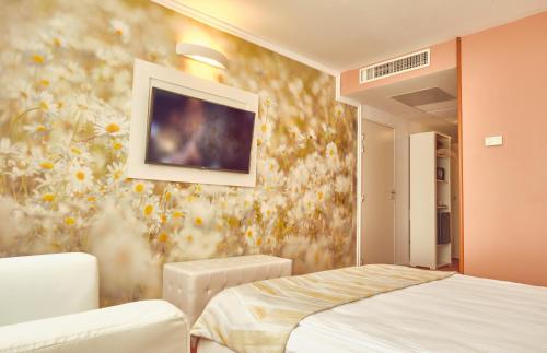 a bedroom with a bed and a flower wallpaper at Continental Forum Bucuresti Palatul Parlamentului in Bucharest