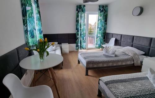 a room with two beds and a table and a table at Tasarz Spa Ośrodek Wczasowy in Rewal