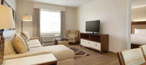 sala de estar con sofá, TV y cama en Homewood Suites By Hilton Oklahoma City Quail Springs, en Oklahoma City